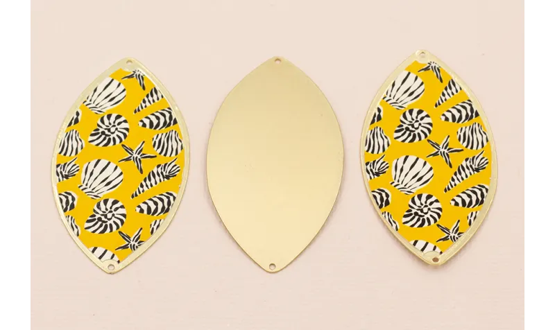 Ovalo 60*33  Oro Mate conchas en fondo Amarillo / Cuentas Metálicas de Latón / Zamak