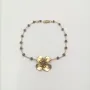 Pulsera facetadas gris y flor oro