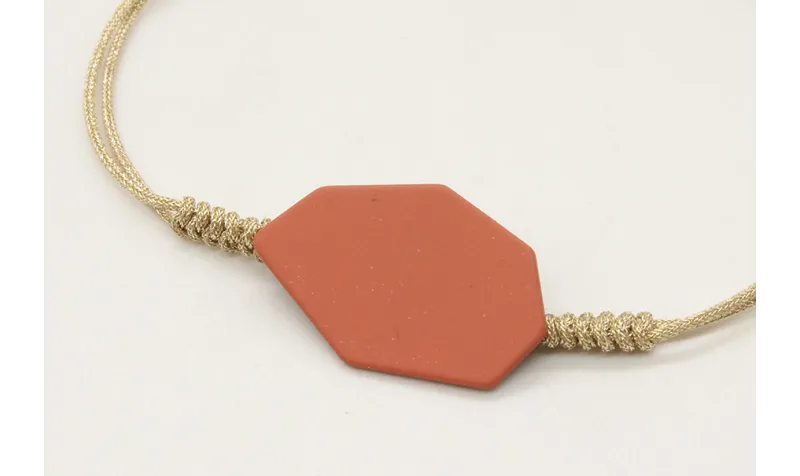 Pulsera nudo serpiente con pieza esmaltada coral. 