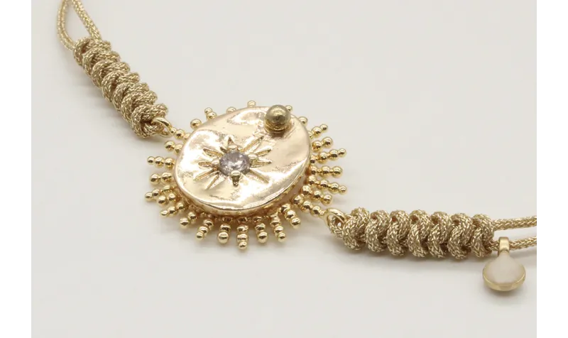 Pulsera nudo serpiente en oro palido con sol y dis