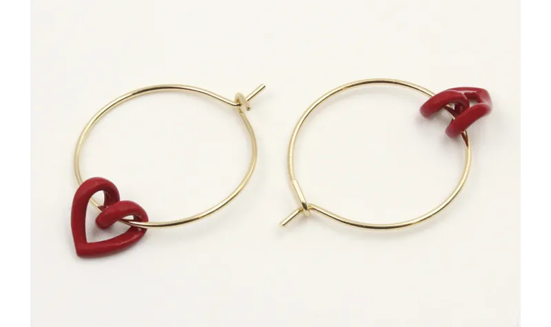 Pendientes aro dorado con corazón hueco rojo.