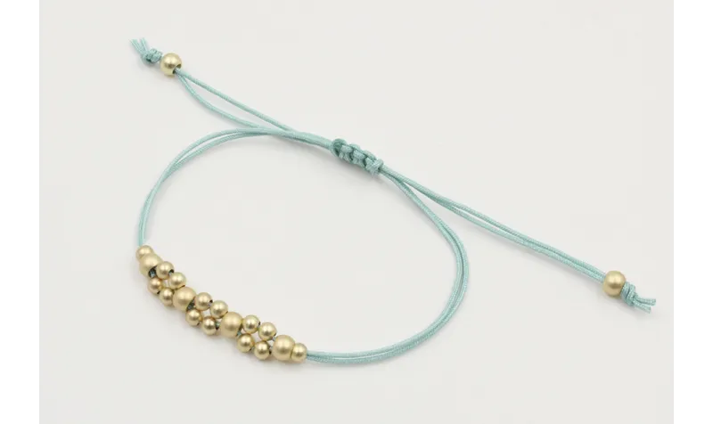 Pulsera hilo macrame menta con  bolas en oro mate.
