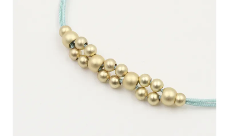 Pulsera hilo macrame menta con  bolas en oro mate.