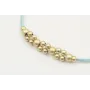 Pulsera hilo macrame menta con  bolas en oro mate.