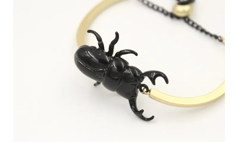 Pulsera semirrigida oro mate con escarabajo esmalt