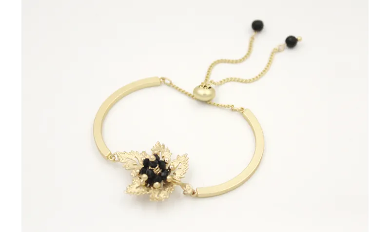Pulsera semi rigida en oro mate con centro hoja de