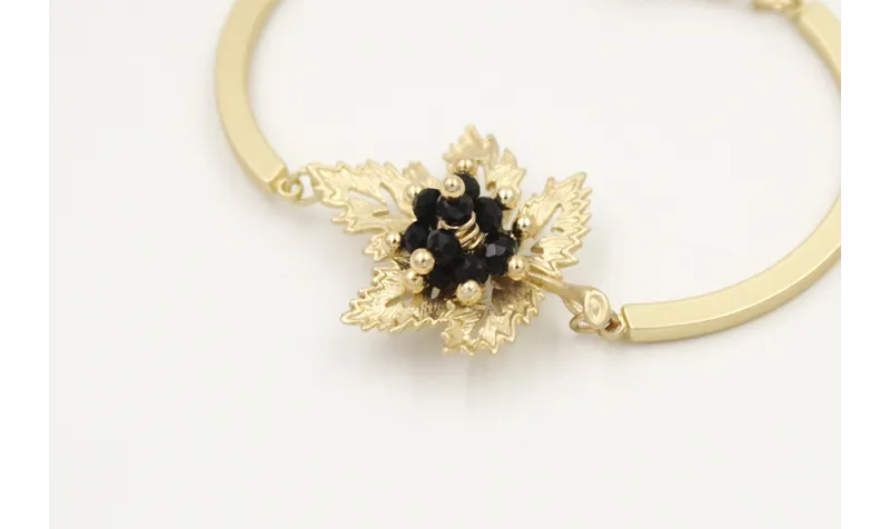 Pulsera semi rigida en oro mate con centro hoja de
