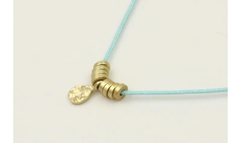 Collar hilo azul con colgante lamina labrada y rue