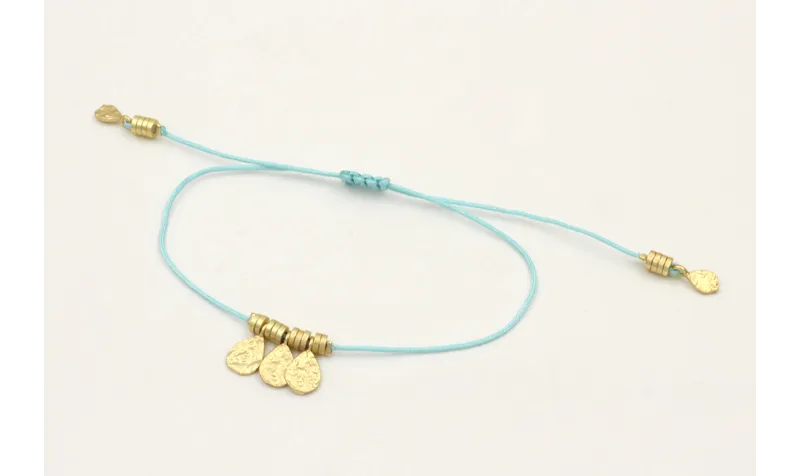 Pulsera hilo azul con colgantes laminas labradas y