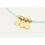 Pulsera hilo azul con colgantes laminas labradas y
