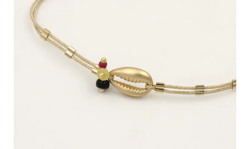 Pulsera hilo dorado palido con tubitos aplastados 